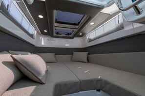 A modern interior with a central seating area, skylight, and built-in air conditioning vents.