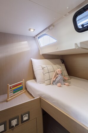 A compact, well-lit room with a bunk bed, a small desk with an abacus, and a window providing natural light. - Sun-Kissed Sailing Adventure in the Dodecanese Islands (Kos)