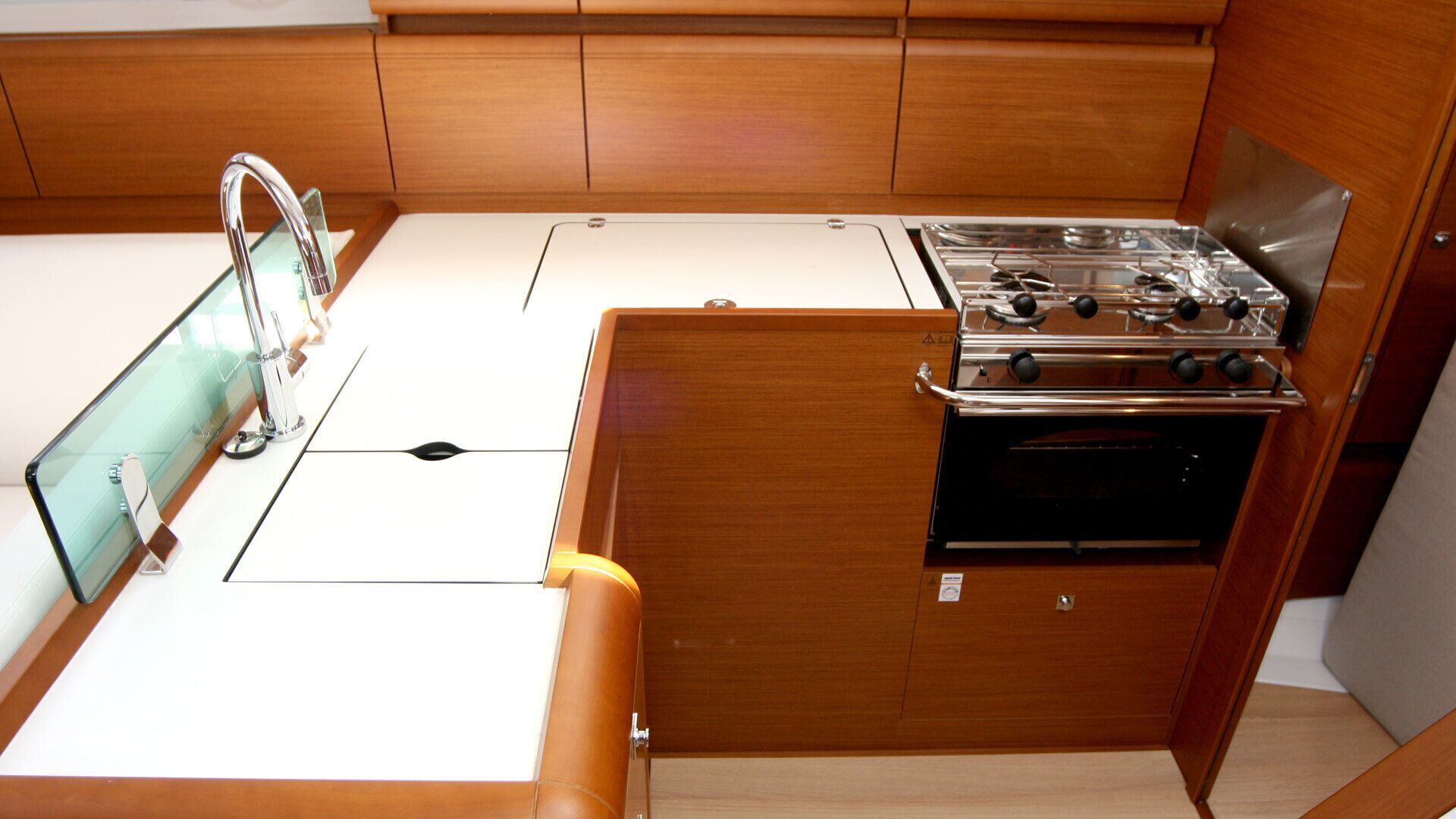 A compact kitchen with a gas stove, oven, and a single faucet.