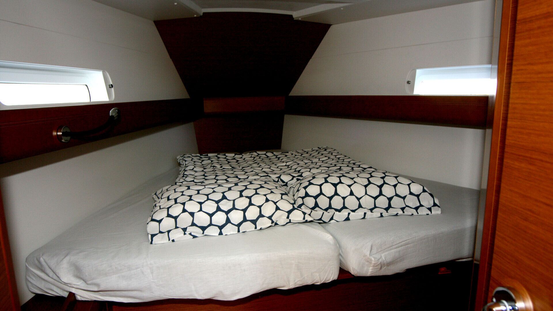 Un lit superposé avec une couvre-lit à motifs et un protège-matelas blanc.