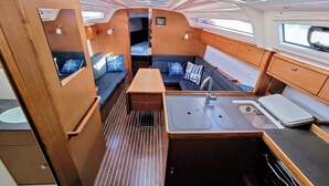 A compact, well-lit interior with a kitchenette, seating area, and a small window. - Sun-Kissed Sailing Adventure in Zadar, Croatia (Bibinje)
