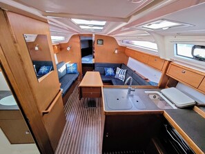 A compact, well-lit interior with a kitchenette, seating area, and a small window. - Sun-Kissed Sailing Adventure in Zadar, Croatia (Bibinje)