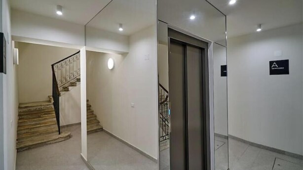 Um interior moderno com uma escada, uma porta e uma placa indicando uma área específica.
