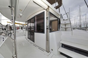 A yacht deck with a glass door, metal railings, and a white hull. - Sun-kissed Sailing Adventure in Split-Dalmatia, Croatia (Trogir)