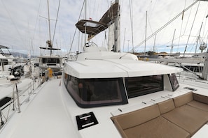 Eine Segelyacht mit überdachtem Deck, mehreren Masten und einer Kabinenstruktur.
