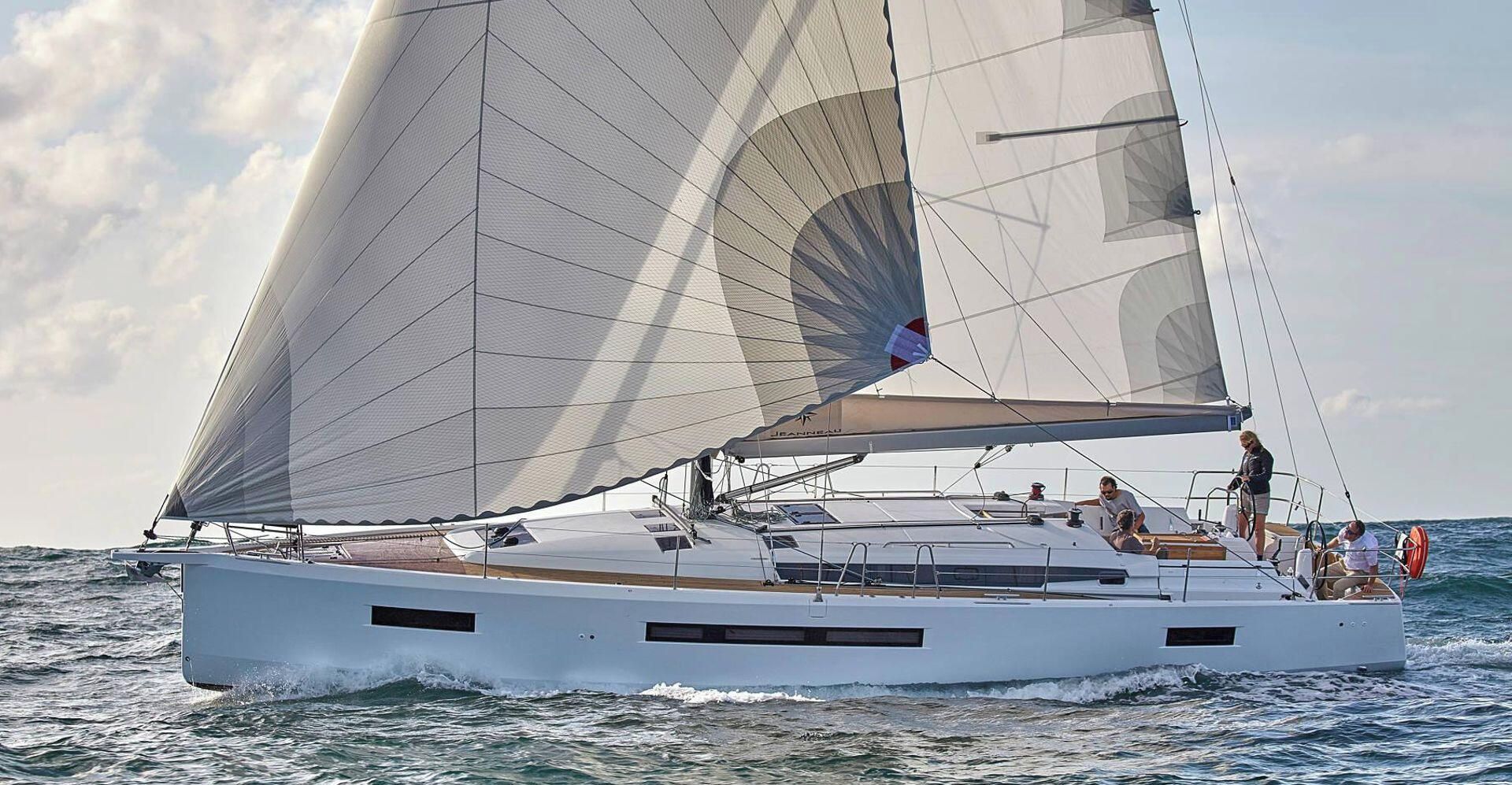 A sailboat with a cabin and deck seating, sailing on the water.