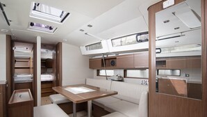 Un intérieur compact et bien éclairé, avec un lit superposé, une petite table et un coin salon.