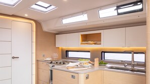 Une cuisine de taille réduite, équipée d’une cuisinière, d’un évier et d’une fenêtre.