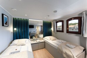 Ein Hotelzimmer mit zwei Betten, einem kleinen Schreibtisch, einem Spiegel und einem Fernseher.
