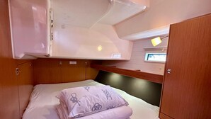 A compact, well-lit cabin with a bunk bed, a small seating area, and a window with a view. - Sun-Kissed Sailing Adventure in Zadar, Croatia (Bibinje)