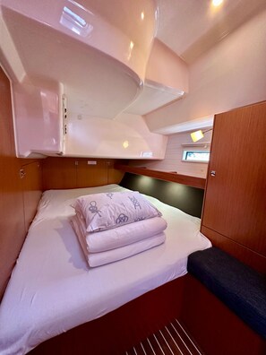 A compact, well-lit cabin with a bunk bed, a small seating area, and a window with a view. - Sun-Kissed Sailing Adventure in Zadar, Croatia (Bibinje)