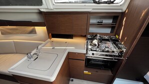 A compact kitchen with a sink, stove, and storage cabinets. - Sun-Kissed Sailing Adventure in Zadar, Croatia (Bibinje)