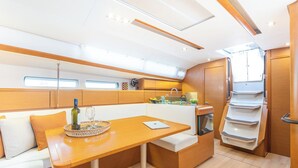 Um espaço interior compacto e bem iluminado, com área de refeições, kitchenette e zona de estar.