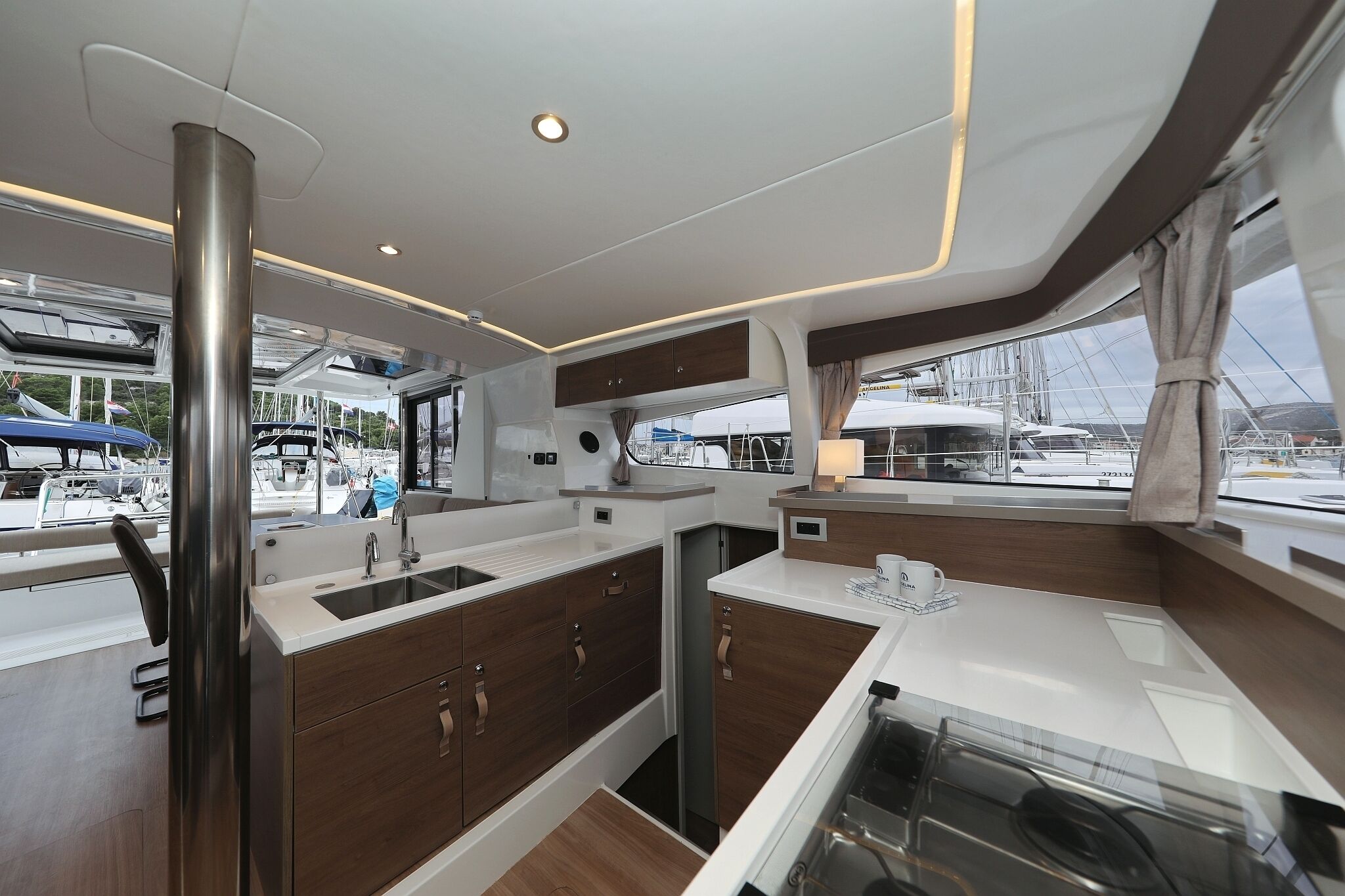 Una cocina moderna con electrodomésticos de acero inoxidable, armarios de madera y un ventanal con vistas al puerto deportivo.