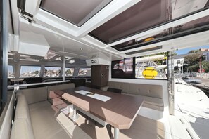 Ein modernes Interieur mit großem Tisch, Sitzgelegenheiten und Blick auf den Hafen.