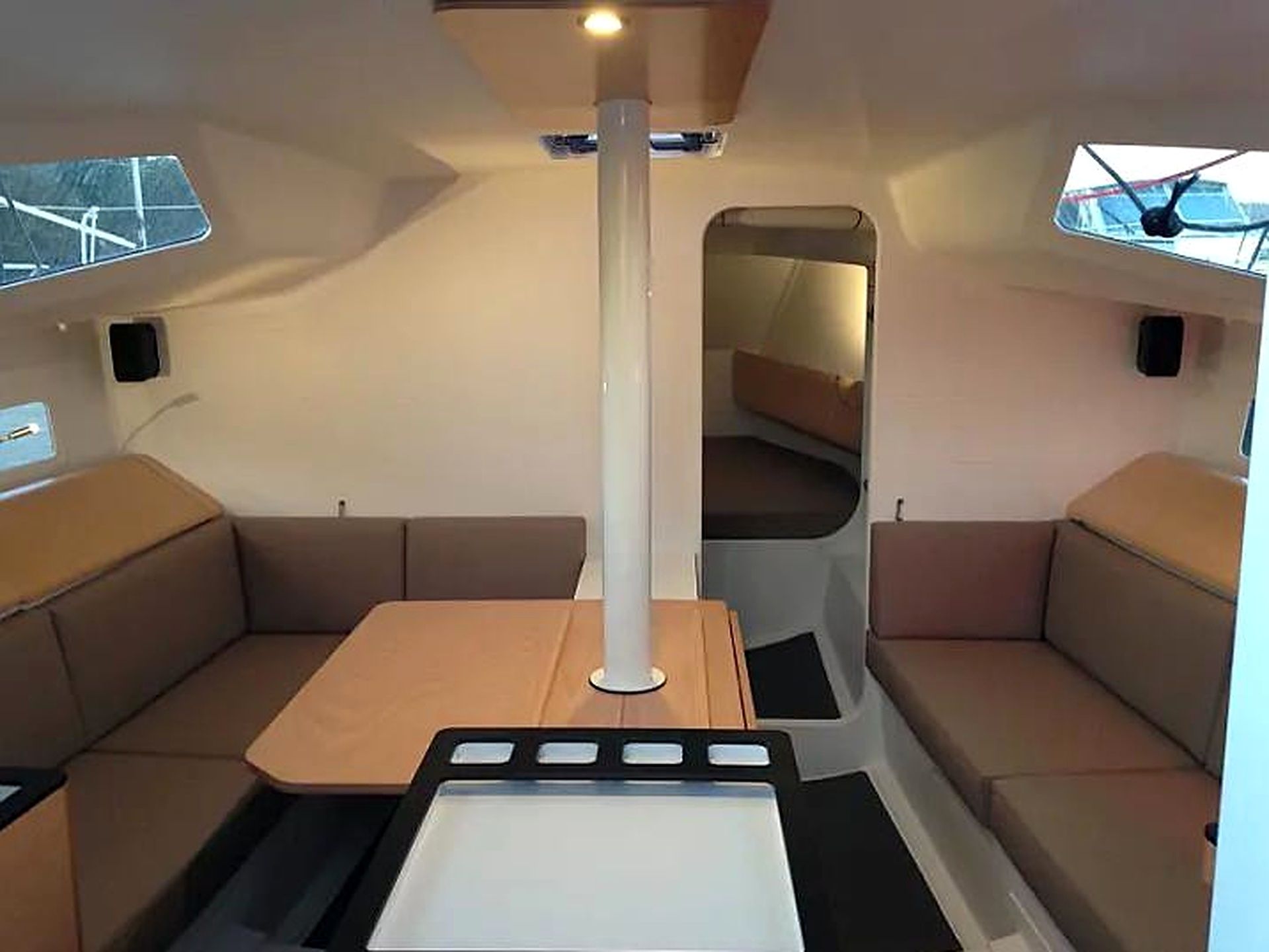 A compact interior with a central table, cushioned seating, and a large mirror.