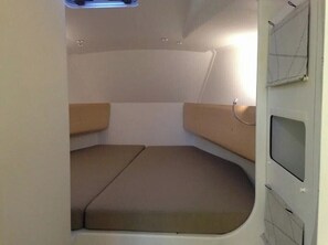 A compact interior with a bed, a small table, and a window.