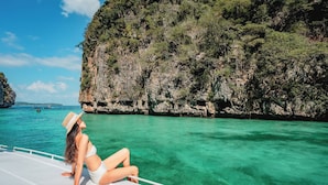 A person sitting on a boat deck with a view of a clear blue sea and rocky cliffs. - Sun-Kissed Sailing Adventure in Split-Dalmatia, Croatia (Marina)