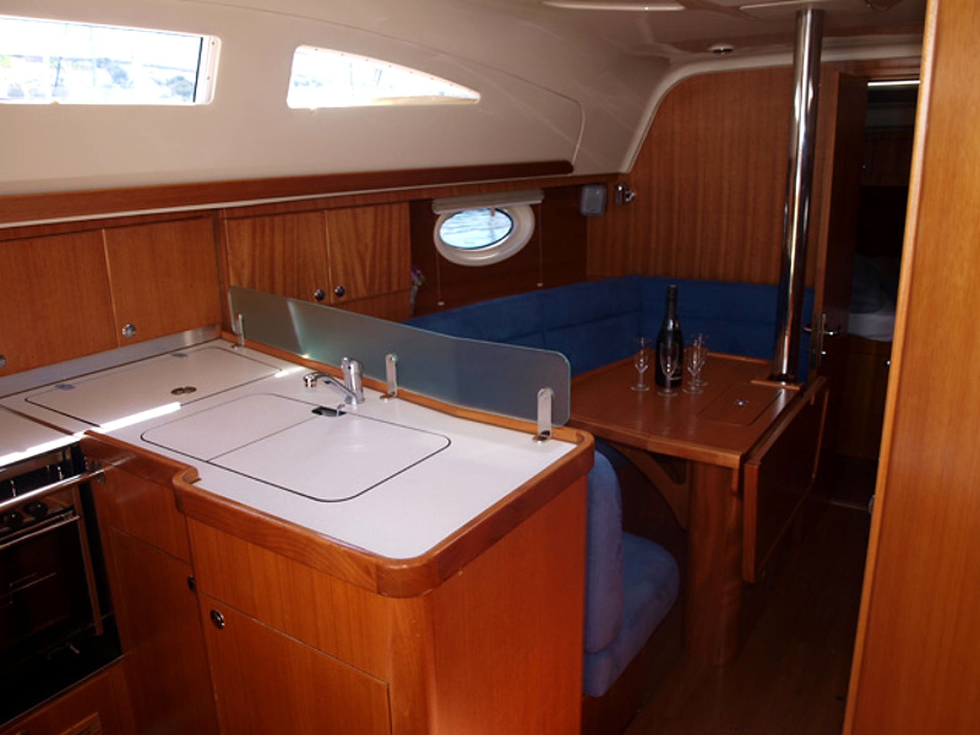 A compact galley with a sink, stove, and a small window.