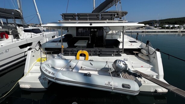 Eine Yacht mit überdachter Plicht, einer Winde und einem Rettungsring.