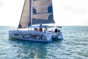 A sailboat with a cabin, a person at the helm, and another person on the deck. - Sun-kissed Sailing Adventure in Split-Dalmatia, Croatia (Trogir)