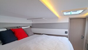 A modern bedroom with a bed, pillows, a wardrobe, and a skylight. - Sun-Kissed Sailing Adventure in Zadar, Croatia (Bibinje)