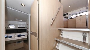 En kompakt og moderne kitchenette med indbyggede hårde hvidevarer, et lille opholdsområde og et klapbord.