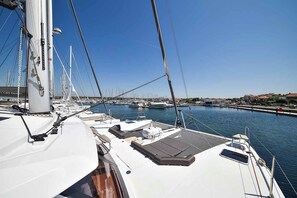 A marina with multiple boats docked, clear skies, and a calm water body.