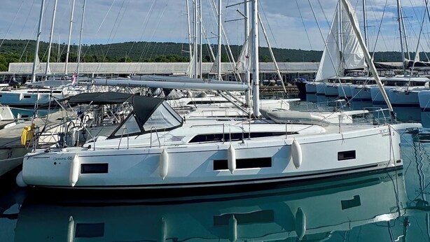 A marina with multiple sailboats docked, clear skies, and a forested landscape in the background. - Sun-Kissed Sailing Adventure in Zadar, Croatia (Bibinje)