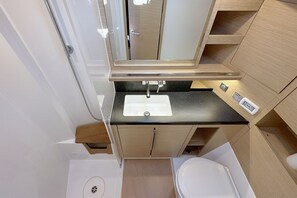 A compact bathroom with a white sink, a mirror, and a toilet. - Sun-Kissed Sailing Adventure in Istria, Croatia (Pula)