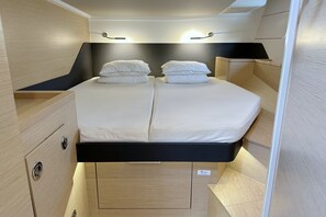 A compact, well-lit bedroom with a bed, bedside tables, and a headboard. - Sun-Kissed Sailing Adventure in Istria, Croatia (Pula)