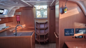Una cocina compacta con lavamanos, armarios de madera y una ventana.