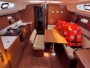 A compact boat interior with a kitchenette, seating area, and a small bathroom. - Sun-Kissed Sailing Adventure in Zadar, Croatia (Bibinje)