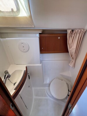 Ein kleines Badezimmer mit Toilette, Waschbecken und Duschbereich.