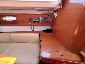 A cabin interior with a wooden console, a communication device, and a cushioned seating area. - Sun-Kissed Sailing Adventure in Zadar, Croatia (Bibinje)