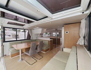 A compact, modern interior with a dining area, seating, and a kitchenette. - Sun-kissed Sailing Adventure in Split-Dalmatia, Croatia (Trogir)