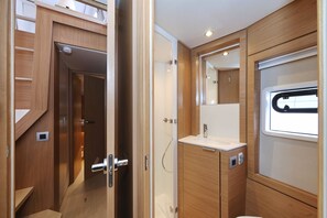 Ein kleines, modernes Badezimmer mit einem Holzwaschtisch, einem Spiegel und einem Fenster.