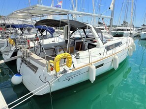 A sailboat docked at a marina with a cabin, a covered seating area, and life rings. - Sun-Kissed Sailing Adventure in Zadar, Croatia (Bibinje)