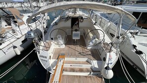 A boat deck with a steering wheel, a small table, and a sign that reads 'GARBIN RIEKA'. - Sun-Kissed Sailing Adventure in Northern Croatia (Punat)