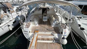 Un pont de bateau équipé d’un volant, d’une petite table et d’une pancarte sur laquelle on peut lire : « GARBIN RIEKA ».