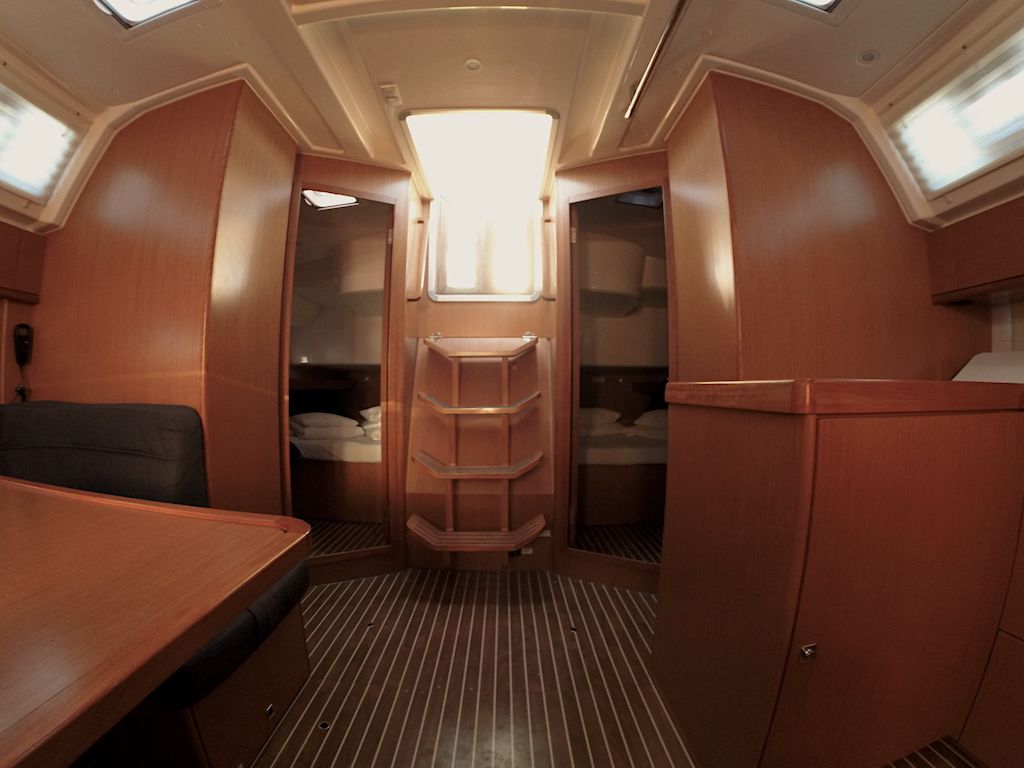 A compact interior with a bed, a small table, and a wardrobe.