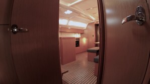 A room with a wooden door, a kitchenette, a bench, and a sloped ceiling with skylights. - Sun-Kissed Sailing Adventure in Zadar, Croatia (Zadar)