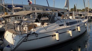 A white yacht named 'Cruiser 46' docked at a marina with other boats, a clear sky, and a building in the background. - Sun-Kissed Sailing Adventure in Zadar, Croatia (Zadar)