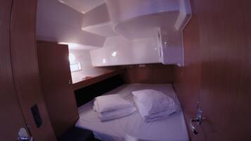 A compact cabin with a bunk bed, a small desk, and a window.