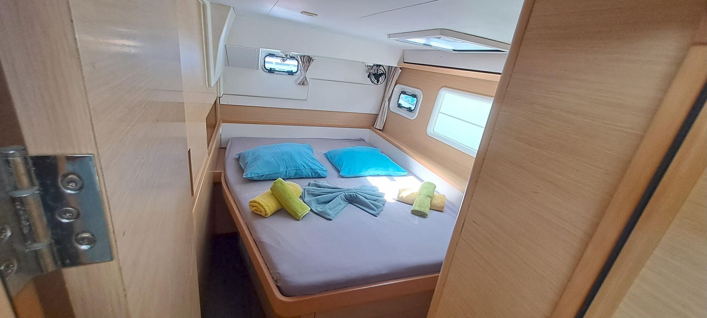 Une chambre à coucher de taille réduite, avec un lit, deux oreillers et une petite fenêtre.