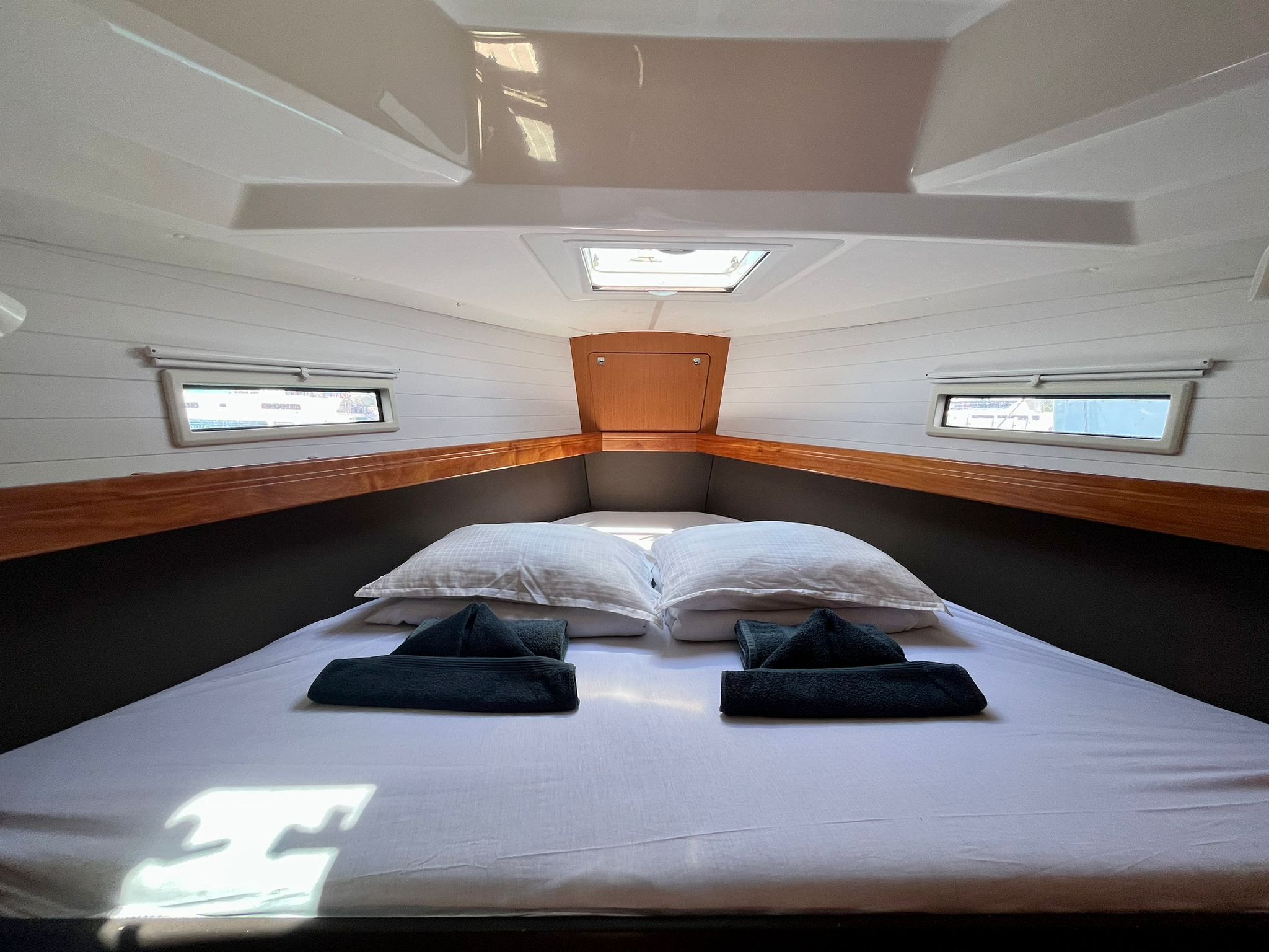 Un petit camping-car étroit, équipé d’un lit simple, d’un puits de lumière, de deux fenêtres et d’une porte en bois.