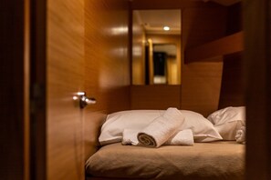 A hotel room with a bed, a wooden door, and a mirror reflecting the room. - Sun-Kissed Sailing Adventure in the Ionian Islands, Lefkada (Lefkada)