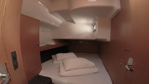 Een compacte blokhut met een stapelbed, een klein bankje en een ingebouwde plank.