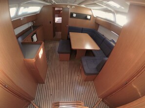Un espacio interior funcional con comedor, asientos y una pequeña kitchenette.