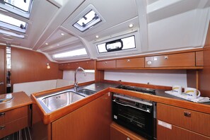 A compact galley with a sink, stove, and storage cabinets. - Sun-Kissed Sailing Adventure in Zadar, Croatia (Biograd na moru)